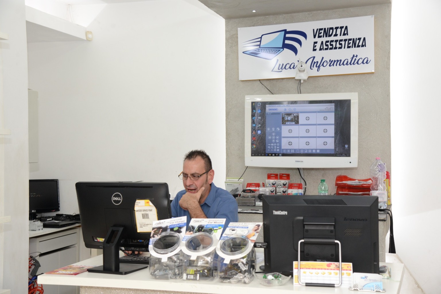 Foto reale dell'interno del negozio Luca's Informatica, con una persona al banco
